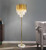 Gold floor lamp with marble base - This  Gold floor standing chandelier lamp  is a stunning and luxurious lighting fixture that brings elegance and sophistication to any space. With its tall and commanding presence, this lamp serves as a focal point, creating a captivating visual impact. The gold finish adds a touch of opulence, exuding a sense of luxury and refinement. The chandelier design features multiple arms adorned with intricate detailing, reminiscent of a traditional chandelier suspended from the ceiling. Crystals or glass accents dangle from the arms, creating a dazzling display as they catch and reflect light. The floor standing design allows for easy placement and versatility, making it suitable for various areas such as living rooms, dining rooms, or entryways. This floor standing chandelier lamp adds a touch of grandeur and transforms any room into a glamorous and inviting space. It combines the beauty of a chandelier with the convenience of a freestanding lamp, providing both functional lighting and an exquisite decorative element. Whether used as a statement piece or to enhance the overall ambiance, a gold floor standing chandelier lamp is a striking addition that adds a sense of sophistication and luxury to your home decor.