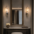 Annalisa Luxury Marble Wall Lights Beside Boutique Hotel Dressing Mirror
Pair of Annalisa marble and brass LED wall sconces illuminating an elegant luxury hotel dressing area with a large framed mirror, marble console and warm ambient lighting.