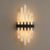 Valeria Sculptural Alabaster Wall Light – Italian Art Deco Designer Sconce. Close-up product view of the Valeria sculptural alabaster wall light, featuring five graduated natural alabaster columns with warm ambient illumination and a contrasting dark metal band. An Italian Art Deco-inspired designer wall sconce ideal for luxury bedrooms, boutique hotels, living rooms, hallways and sophisticated contemporary interiors.