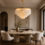 Ottavia Natural Marble Chandelier in Luxury Home Dining Room
The Ottavia 80cm natural marble chandelier suspended above a round marble dining table in an elegant luxury home, showcasing its tiered Art Deco silhouette, warm gold detailing and softly illuminated stone panels in a refined residential interior.