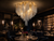 Celestine Hollywood Regency Chandelier in Fine Dining Restaurant
The Celestine silver tassel and gold frame chandelier illuminating a dark, sophisticated fine dining restaurant with velvet seating, marble tables and atmospheric lighting, ideal for luxury restaurants, cocktail lounges and boutique hospitality interiors.