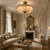 Élodie Antique Brass Ceiling Light in Grand Neoclassical Salon
The Élodie fabric ceiling light positioned in a luxurious French-style salon featuring ornate plasterwork, gilt detailing, traditional seating and a marble fireplace, ideal for elegant period homes and château-inspired interiors.