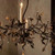 atmospheric lighting, warm lighting glow, candle effect lighting, multi-branch chandelier, sprawling chandelier design, wide chandelier fixture, large span lighting, grand room centerpiece, premium ceiling fixture, luxury hospitality lighting, historic manor decor, stately home lighting, rich aesthetic decor, ornate scrollwork, organic design lighting, forest canopy chandelier, twisting branch fixture, botanical chandelier, metallic leaf decor,