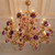 royal palace decor style, sophisticated interior lighting, vintage gold lighting, custom floral chandelier, dramatic ceiling light, romantic lighting fixture, upscale room decor, historic home lighting, regency core aesthetic, elegant foyer lighting, ceramic rose chandelier, ornate gold chandelier, whimsical interior decor, classic luxury chandelier, traditional European chandelier, vintage romance decor, high-end home accents, decorative floral lighting, aesthetic room lighting, grand chandelier design, luxury dining lighting, elegant living room light,