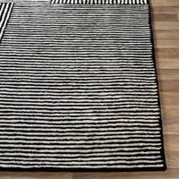 Black & white striped hand-tufted viscose rug with a natural, soft texture on a wood floor.