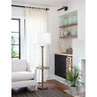 Rustic natural wood floor lamp with a white linen shade and round tabletop surface.