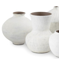 Set of five organic white ceramic vases with handmade textures and varying shapes.