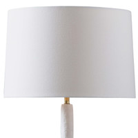 Hope Table Lamp with a matte white curved base, polished brass accent, and a white linen shade.