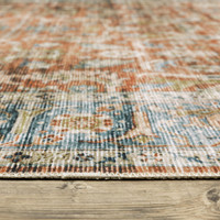 Charleston Rust & Blue washable polyester rug with distressed traditional patterns and blanket stitch finish on wood floor.