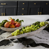 Long whitewashed Ardu wood decorative tray filled with green grapes on a marble counter.