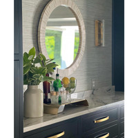 Round multitone bone tile mirror with slender striping, reflecting a coastal look.