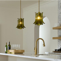 Two Calla Peridot Green Glass Pendants with antique brass hardware illuminate a kitchen island.