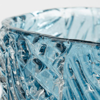 Close-up of a blue cast glass decorative bowl with a textured surface and unique light effects.