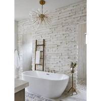 Poppy semi-flush mount light with natural brass rods and undulating clear glass discs over a white bathtub.