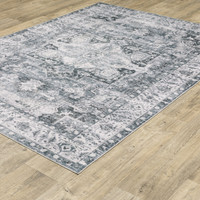 Charleston Charcoal & Ivory Washable Rug with distressed traditional patterns on a wood floor.