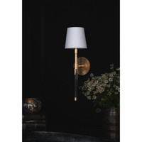 Auburn brass and crystal sconce with a white linen shade on a dark wall.