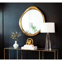 Ibiza Mirror with organic antique gold frame, reflecting a room, above a console table.