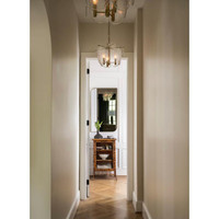 Echo Pendant with water glass panes and brass accents, illuminating a hallway.