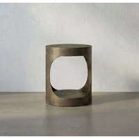 Eclipse Round Aged Brass Side Table, a modern metal table with a unique oval cutout design.