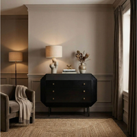 Black mahogany Rhiana vanity dresser with angled edges, tall slim legs, and three drawers.
