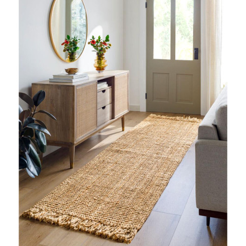 Light brown chunky hand-woven jute rug runner with fringe in a natural entryway.