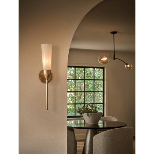 Mousseaux fluted glass and natural brass sconce, 22" tall, on a beige wall.