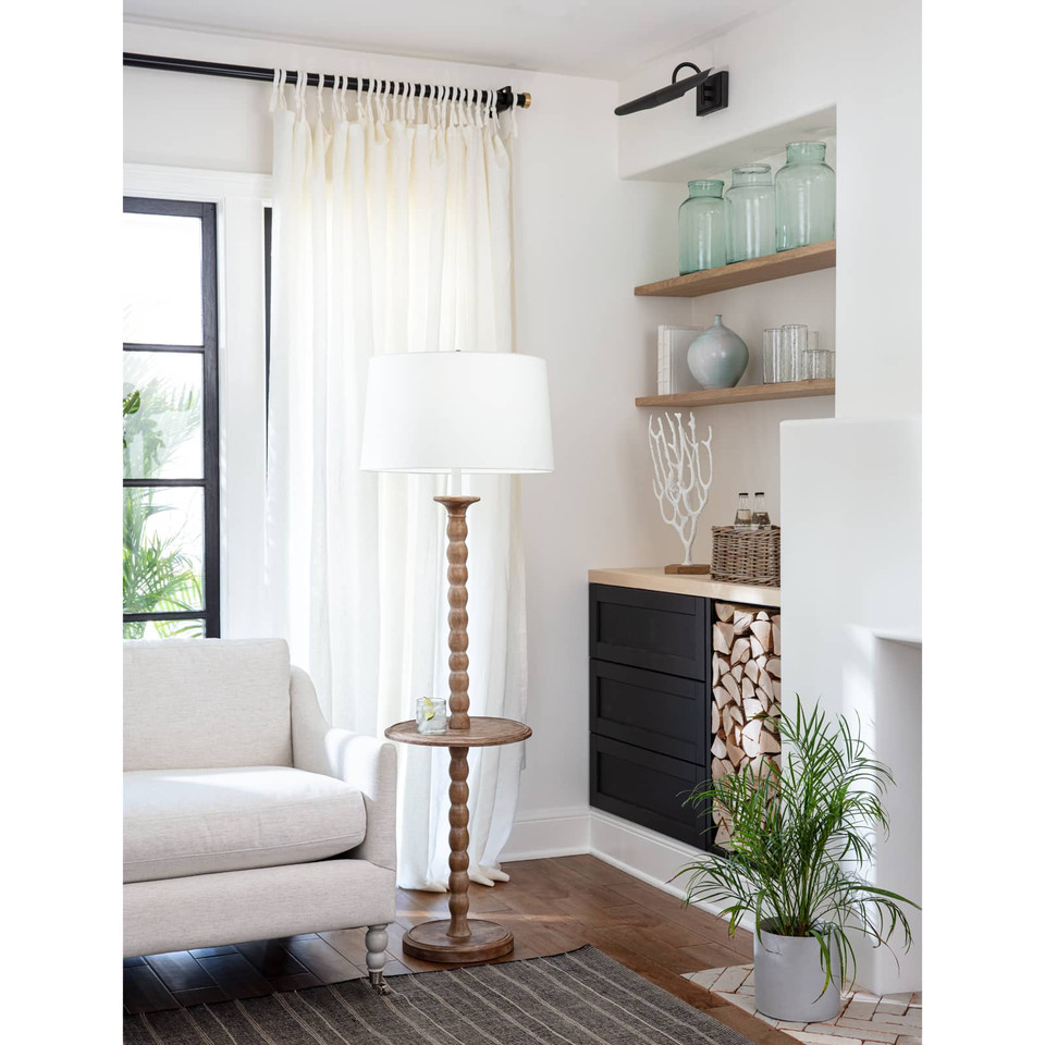 Rustic natural wood floor lamp with a white linen shade and round tabletop surface.