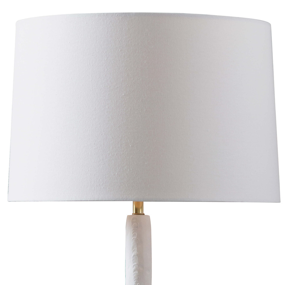 Hope Table Lamp with a matte white curved base, polished brass accent, and a white linen shade.