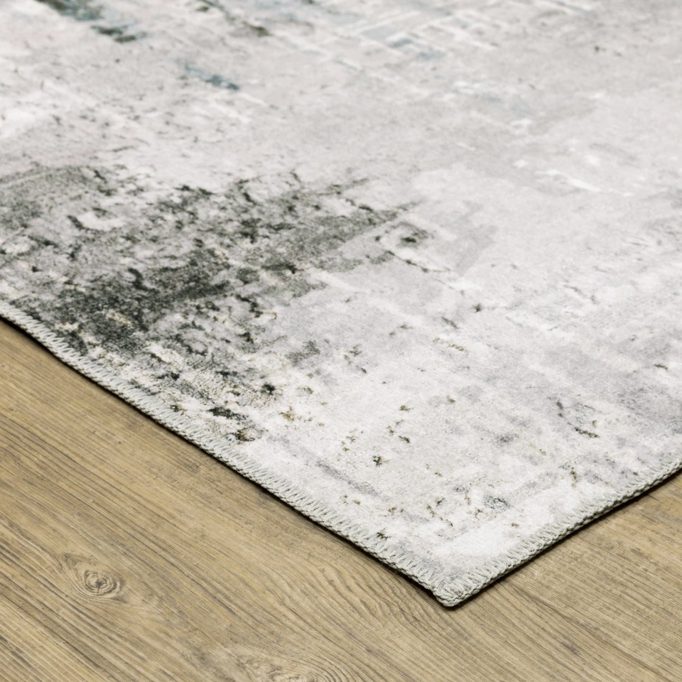 Malibu Grey & Multi washable polyester rug with abstract design on a wooden floor.
