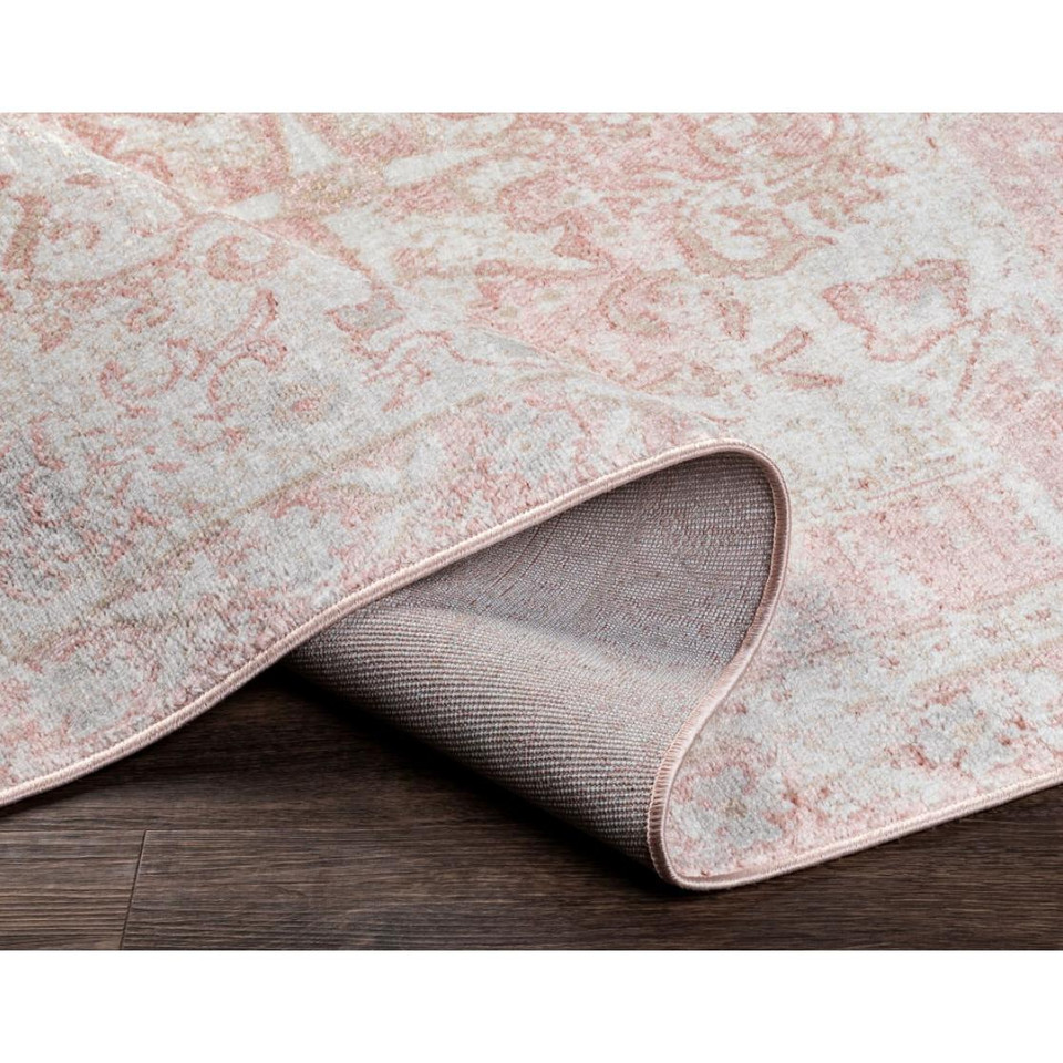 St Tropez pale pink and beige polypropylene rug with traditional design, partially rolled on a wood floor.