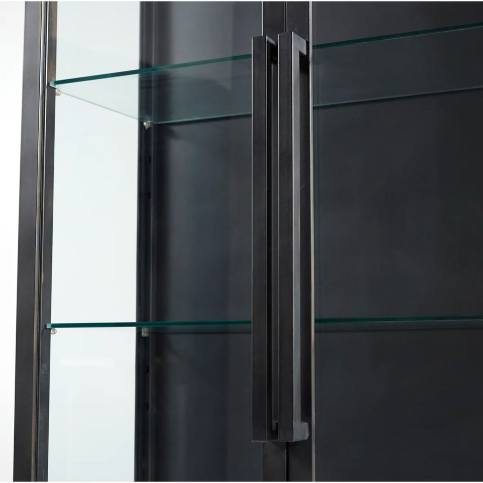 Black iron curio cabinet with glass shelves and a long, dark handle.
