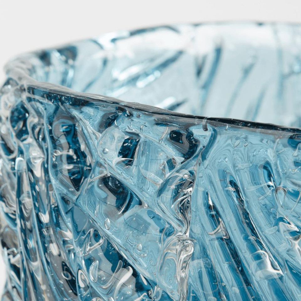 Close-up of a blue cast glass decorative bowl with a textured surface and unique light effects.