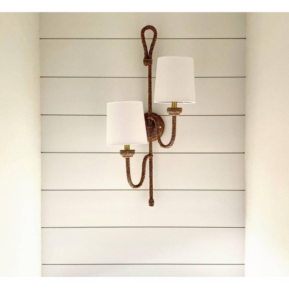 Bimini Double Sconce with natural woven seagrass, looped detailing, and two white linen shades on a white shiplap wall.