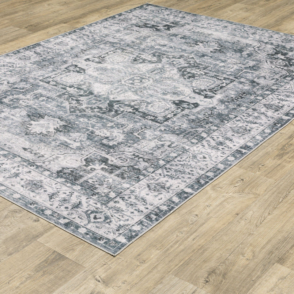 Charleston Charcoal & Ivory Washable Rug with distressed traditional patterns on a wood floor.