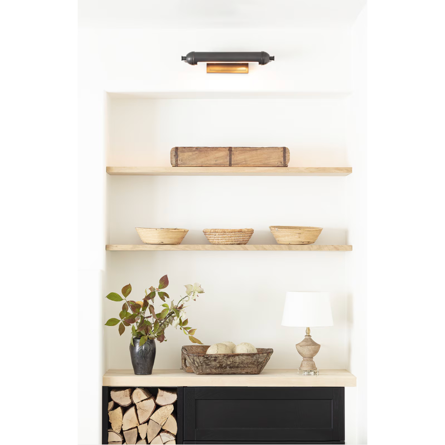 Devon Small Picture Light in oil rubbed bronze, illuminating a white shelf with decor.