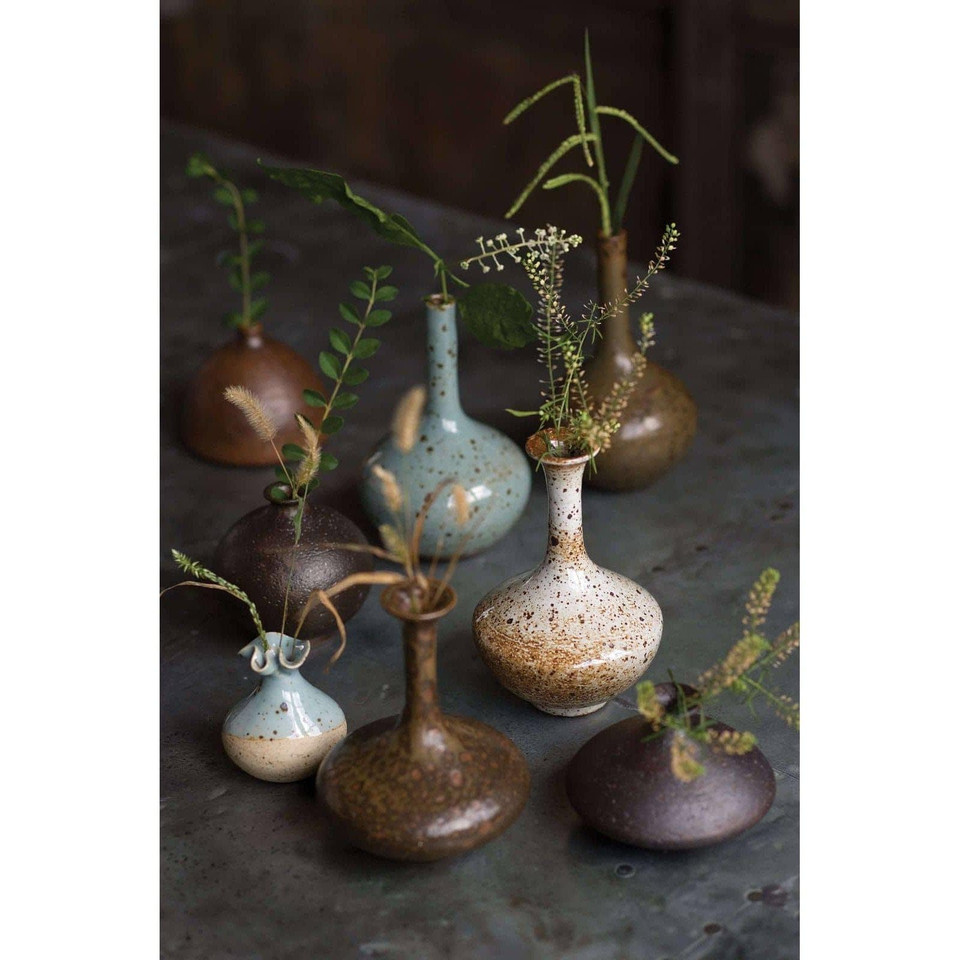 Eclectic set of 8 handmade porcelain bud vases in varying shapes, sizes, and colors, from blue to brown.
