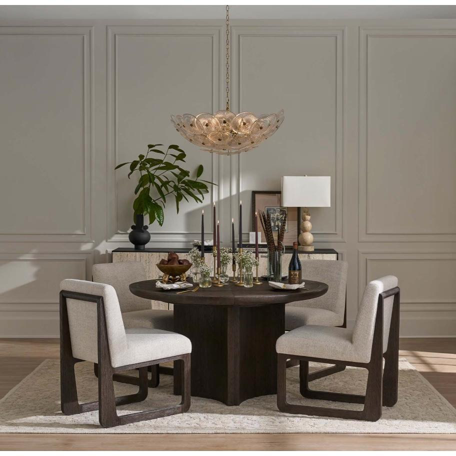 Holly Disc Chandelier with clear smoke glass discs and brass finials, suspended over a dining table.