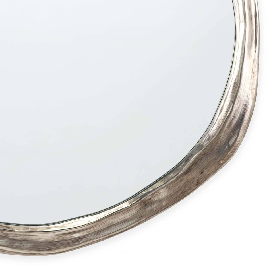 Ibiza Mirror: organic, undulating circular shape with an antique silver frame and warm, ambered glow.