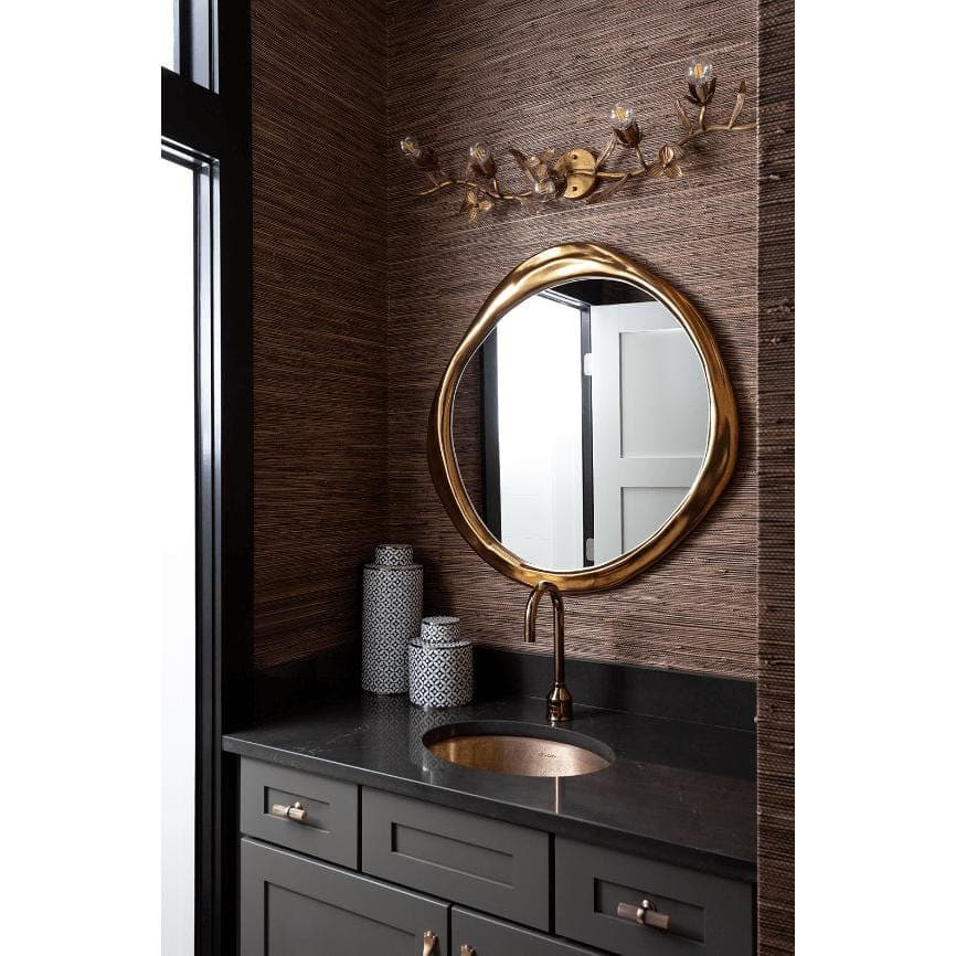 Trillium Sconce with antique gold leaf branches and five candelabra lights above a vanity.