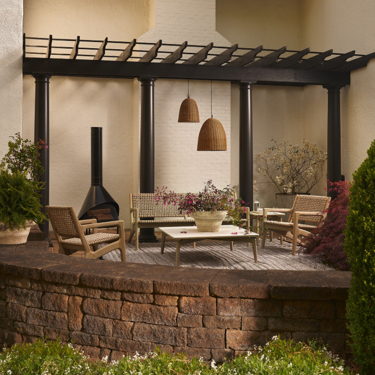 Two large, weathered natural rattan beehive outdoor pendant lights hanging over a patio seating area.