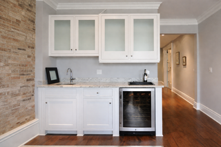 Custom built ins bar and coffee nook with white raised panel doors and foggy glass cabinets