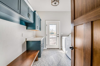 Custom built ins laundry room with upper cabinets and folding counter in a recessed wall space