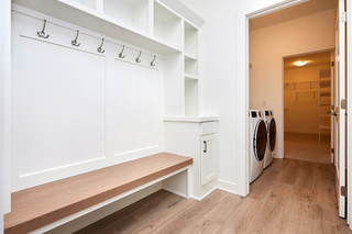 Custom built ins laundry room cabinets with base storage and overhead shelving