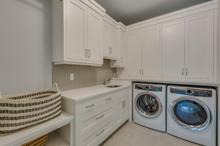 Custom built ins laundry room cabinetry with upper and base storage