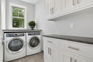 Custom built ins laundry room with tall cabinets and integrated shelving