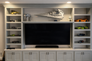 custom built ins media wall with grey shaker doors adjustable shelving and crown molding