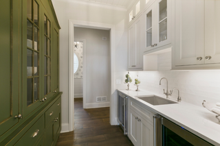 custom built ins butler pantry with green slab drawers and white shaker cabinets