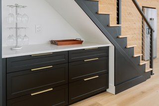 custom built ins under stairs with black shaker thermofoil doors