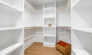 Custom corner walk-in closet shelving system with drawers and hanging storage