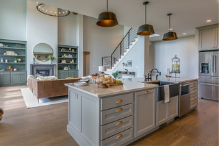 Custom kitchen island with grey shaker panels and slab drawer fronts plus built-in dishwasher for efficient workflow